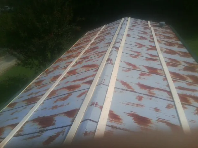 Rusted metal roof panels with new wood purlins before replacement — Storm Damage Roof Repair in Aldrich by Roofing Brothers