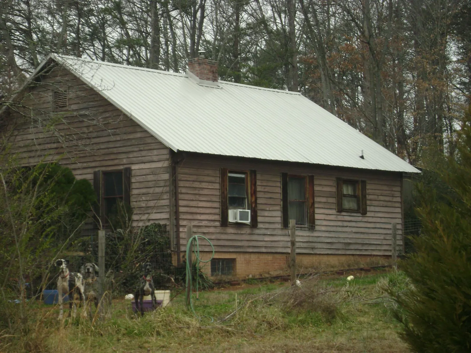 White metal roof on an old wood sided farmhouse, from a Metal Roof Installation job in Aldrich
